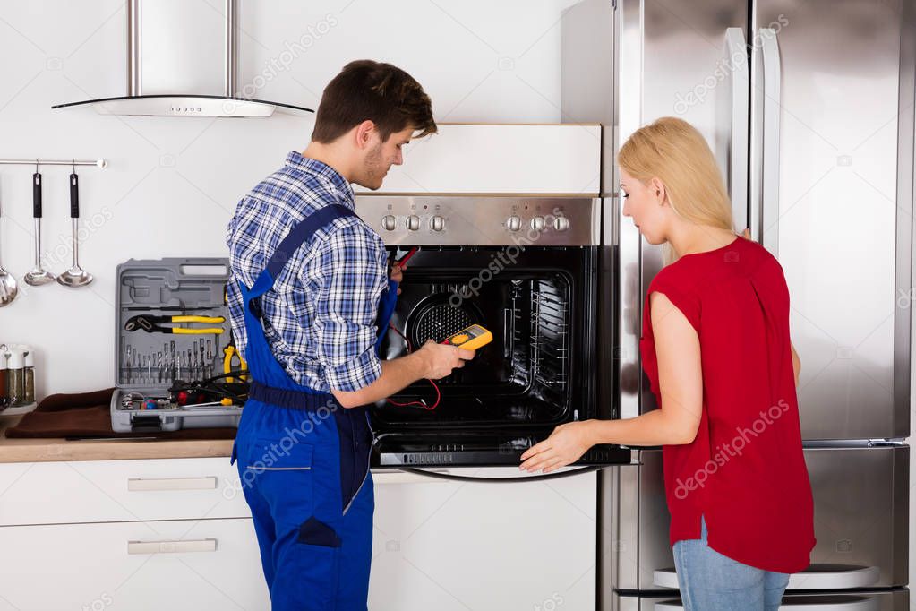 Male Worker Repairing Oven 