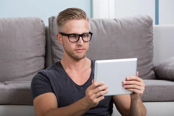 Człowiek patrzący na tablet cyfrowy — Zdjęcie stockowe