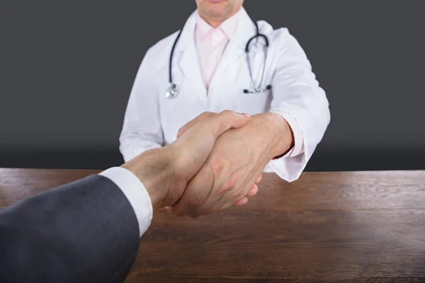 Доктор пожимает руку пациенту — стоковое фото