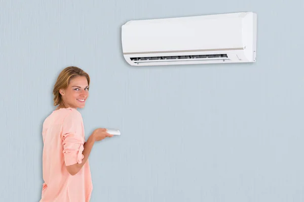 Frau benutzt Klimaanlage — Stockfoto