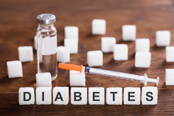 Слово диабет с инсулином и шприцем
