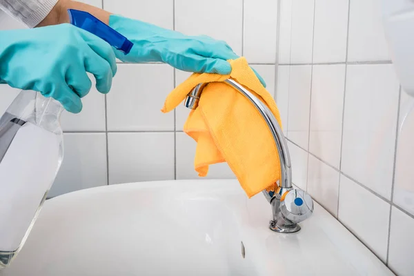 Osoba čištění kohoutek v koupelně — Stock fotografie