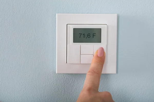 Réglage de la main féminine Le thermostat — Photo