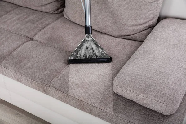 Membersihkan sofa dengan vacuum cleaner — Stok Foto