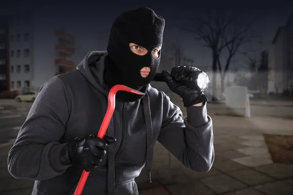 Einbrecher mit Brecheisen und Taschenlampe — Stockfoto