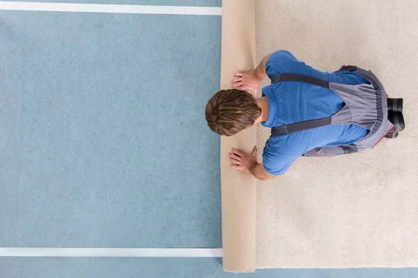 Handyman Rolling Carpet On Floor — Stock Photo, Image
