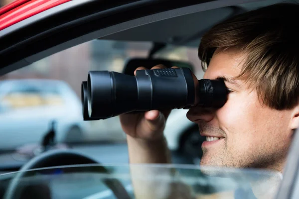 Mann blickt durch Fernglas — Stockfoto