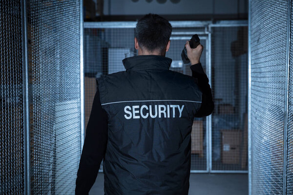 Security Guard Standing In Warehouse