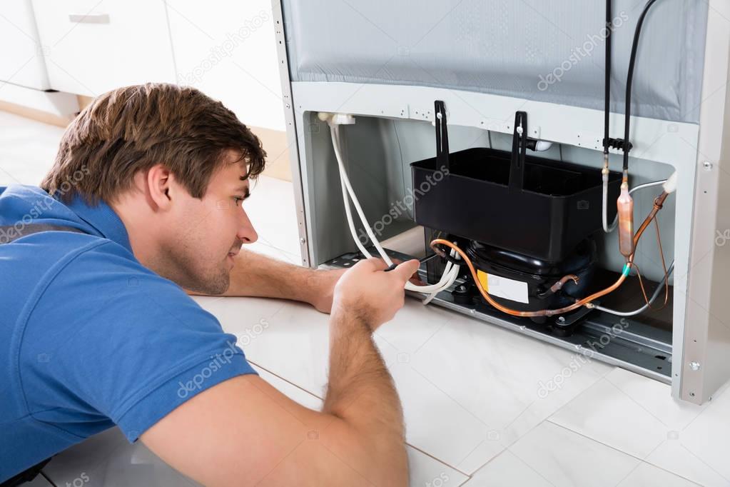 Technician Repairing Refrigerator