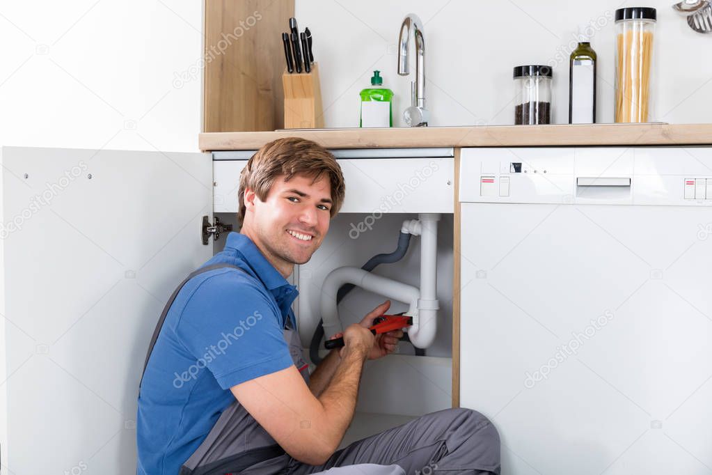 plumber fixing sink pipe