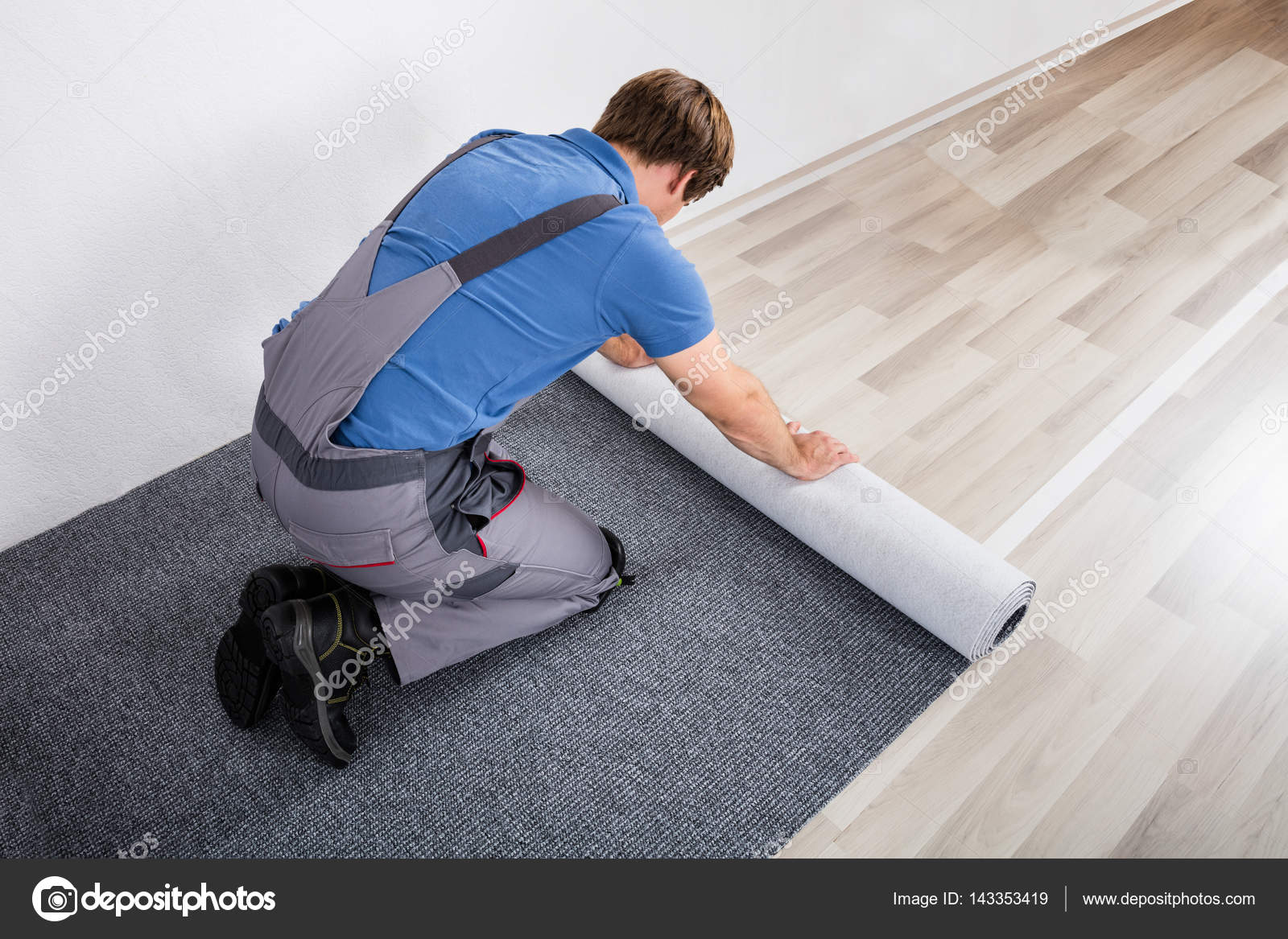 Handyman Rolling Carpet On Floor Stock, Changing From Carpet To Laminate Flooring