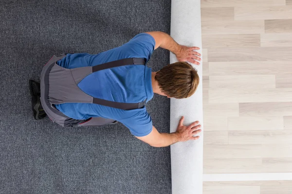 Männliche Arbeiter rollen Teppich — Stockfoto