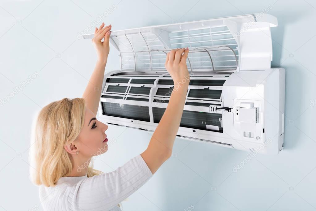 Woman Cleaning Air Conditioning System