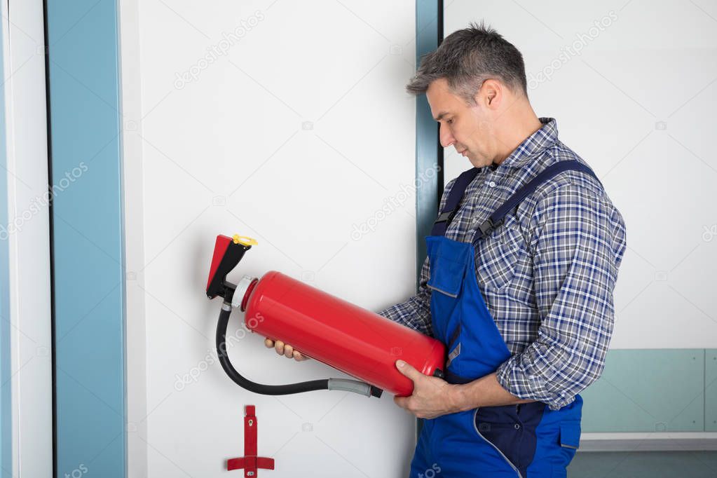 Worker Checking Fire Extinguisher