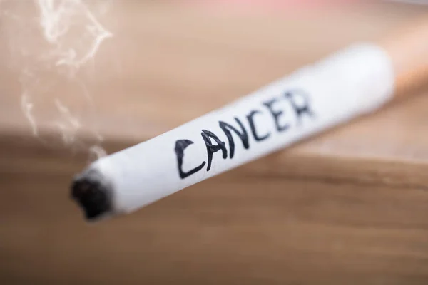 Cancer Text på brinnande cigarett — Stockfoto