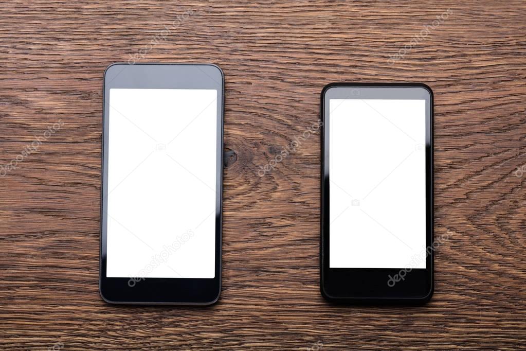 Mobile Phones On Wooden Desk