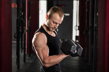 Adam dambılı kaldırıyor.