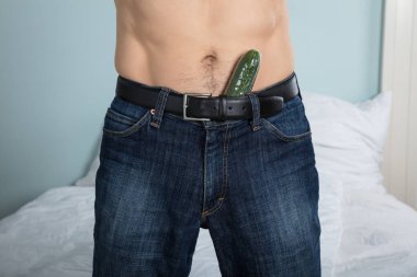 Closeup Of A Person With A Cucumber Stuffed Down His Pants At Home clipart