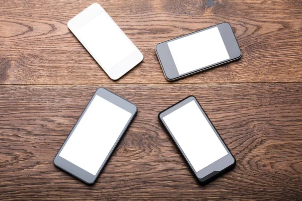 Teléfonos móviles en escritorio de madera —  Fotos de Stock