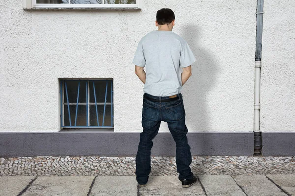 Homme faisant pipi sur le mur du bâtiment — Photo