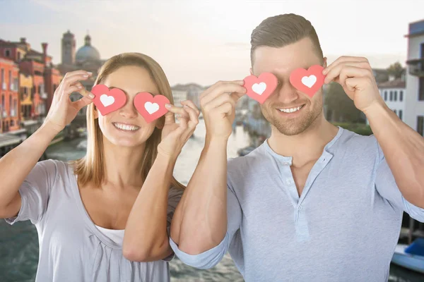 Casal cobrindo os olhos com corações — Fotografia de Stock