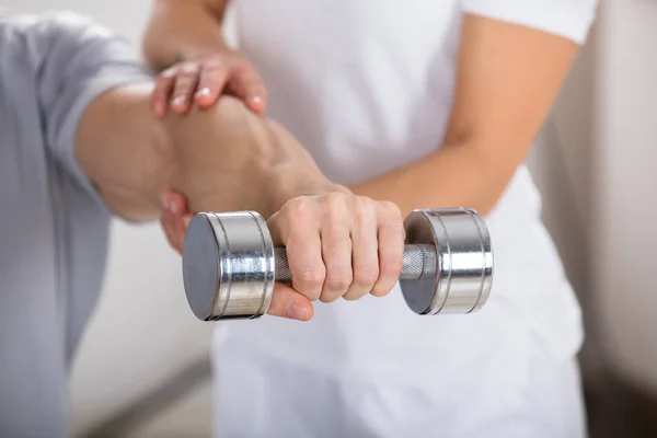Fizjoterapeuta pomaga człowiekowi ćwiczenia — Zdjęcie stockowe