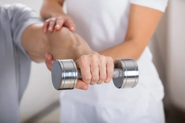 Sjukgymnasten hjälper mannen att övning — Stockfoto