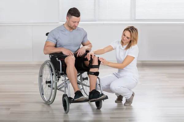 Sjukgymnast fastställande knä hängslen — Stockfoto