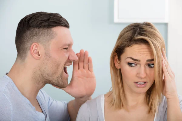 Homem gritando na orelha da esposa — Fotografia de Stock