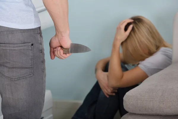Чоловік тримає ніж перед жінкою — стокове фото
