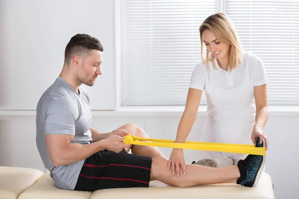 Physiotherapeut macht Übungen mit Band — Stockfoto