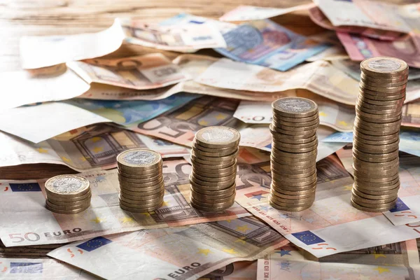 Monete accatastate sulle banconote in euro — Foto Stock