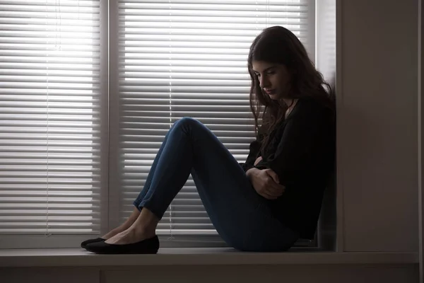 Mulher sentada no parapeito da janela — Fotografia de Stock