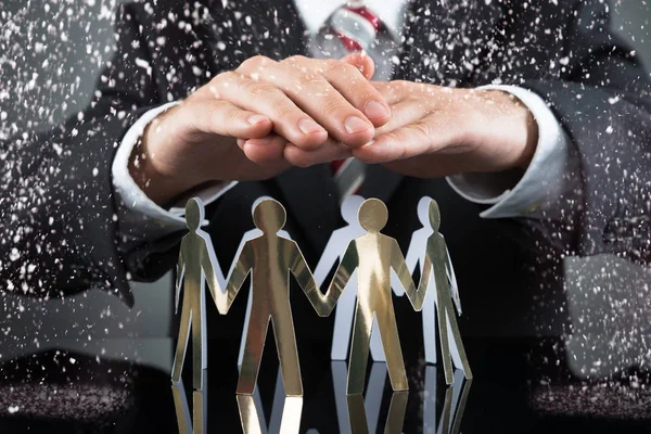 Businessman Protecting Human Figures — Stock Photo, Image