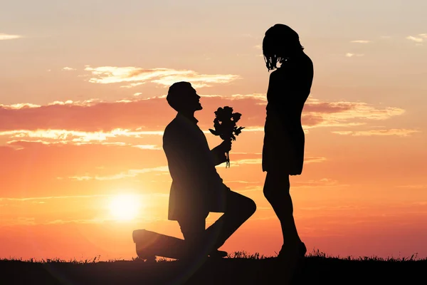 Mann macht Freundin bei Sonnenuntergang einen Heiratsantrag — Stockfoto