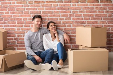  karton kutular arasında oturan Çift