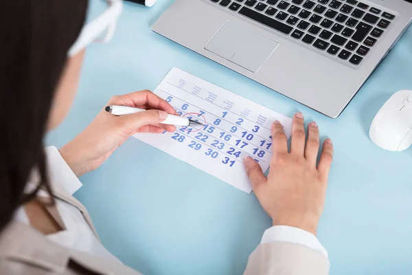 Geschäftsfrau zeichnet Kreis am Kalenderdatum — Stockfoto