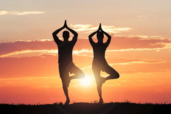 Silueta de pareja haciendo yoga — Foto de Stock