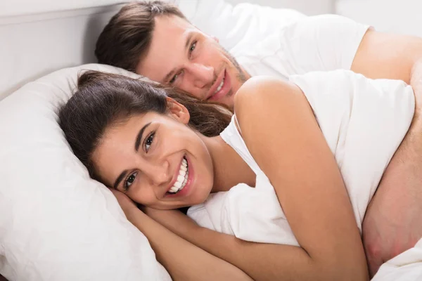 Homme étreignant femme au lit — Photo