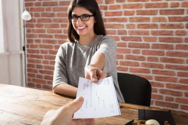 Mujer Ofreciendo cheques de la compañía —  Fotos de Stock