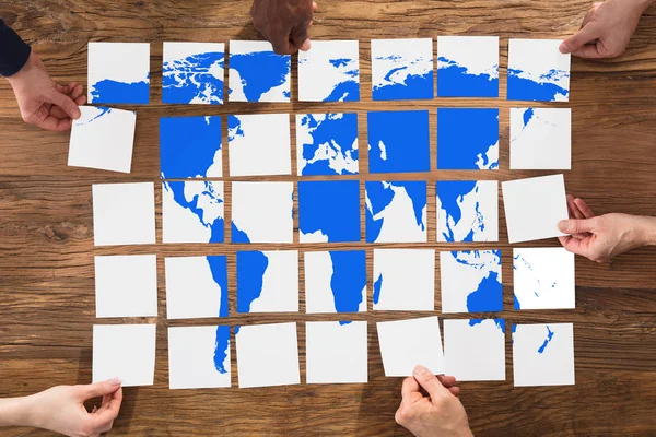 Gente Arreglando mapa del mundo — Foto de Stock