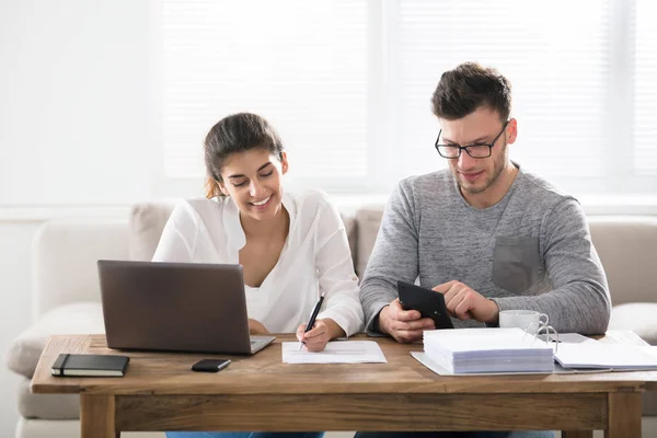 Casal fazendo papelada em casa — Fotografia de Stock