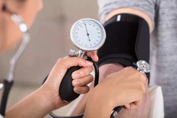 Doctor measuring blood pressure — Stock Photo, Image