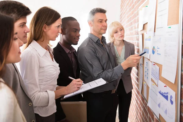 Volwassen Manager Analyseren Van Grafiek Met Zijn Collega Aangesloten Prikbord — Stockfoto