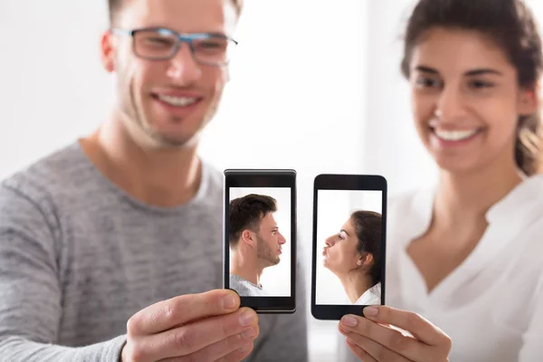 Pareja feliz mostrando su teléfono celular —  Fotos de Stock