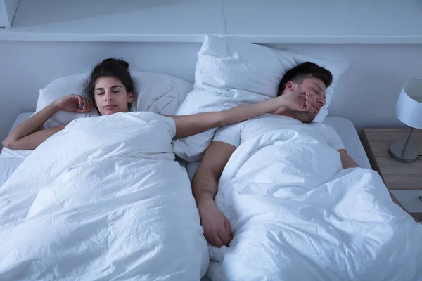 Pareja joven durmiendo en la cama — Foto de Stock