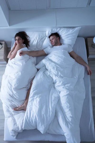 Νεαρό ζευγάρι κοιμάται στο κρεβάτι — Φωτογραφία Αρχείου