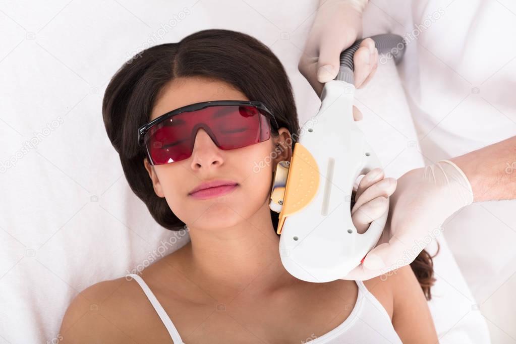 Woman receiving laser epilation treatment