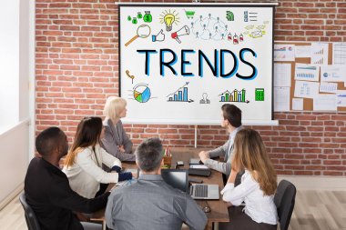 Trendler sunumu projektör iş toplantıda bakarak iş adamları