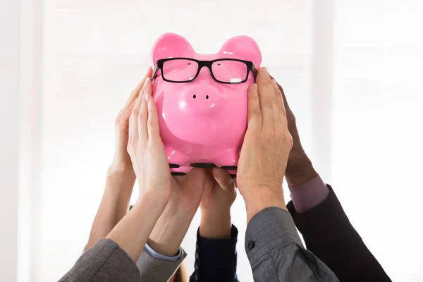 Gruppe Von Geschäftsleuten Hält Rosa Sparschwein Mit Brille Der Hand — Stockfoto